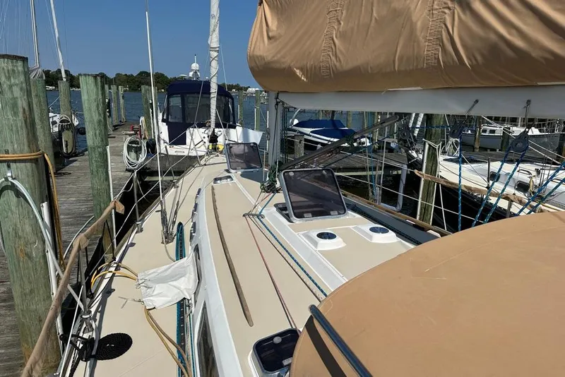 Slide: The Image of 2002 Sabre 402 sailboat docked at marina, featuring tan deck and rigging. - 13