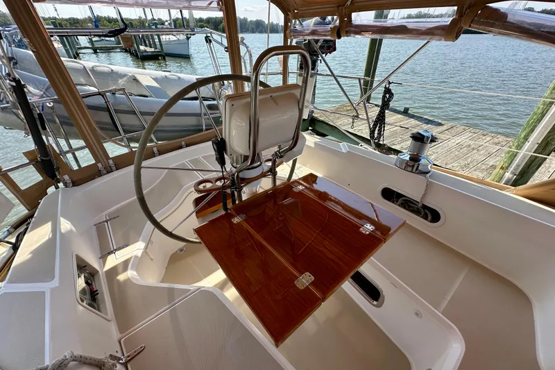 Slide: The Image of Cockpit of 2002 Sabre 402 sailboat with wooden table and steering wheel, docked at marina. - 15