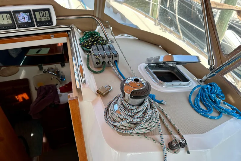 Slide: The Image of 2002 Sabre 402 sailboat cockpit with ropes, winch, and navigation instruments. - 23