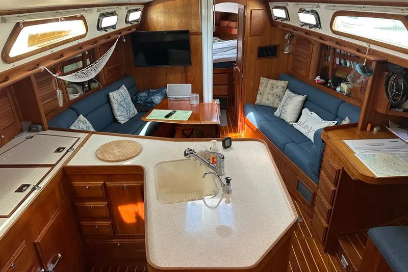 Slide: The Image of Interior of 2002 Sabre 402 sailboat with cozy seating and wooden cabinetry. - 25