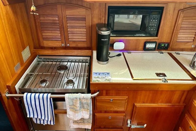 Slide: The Image of Galley kitchen in 2002 Sabre 402 yacht with stove, microwave, and Keurig. - 29