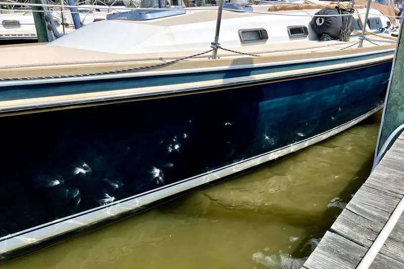 Slide: The Image of 2002 Sabre 402 sailboat docked, showing blue hull and deck details. - 3