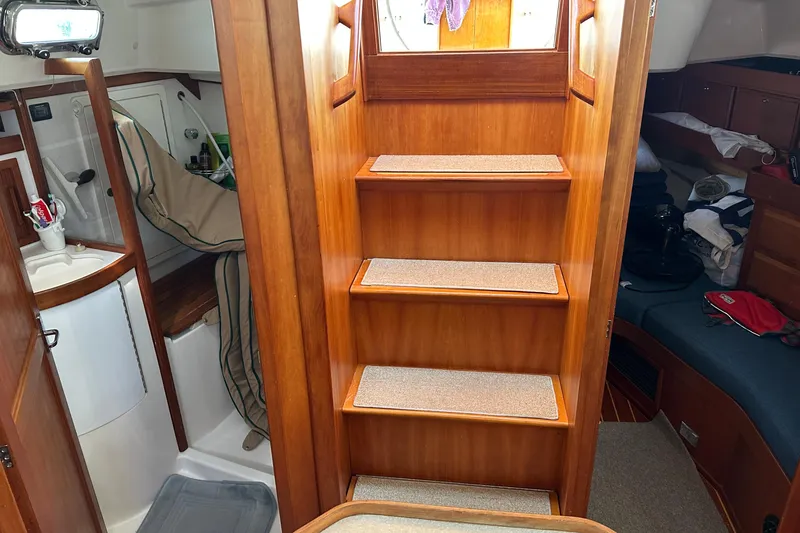 Slide: The Image of Interior of 2002 Sabre 402 sailboat with wooden stairs and compact living space. - 31