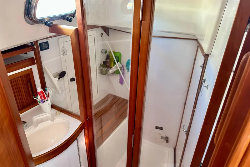 Slide: The Image of 2002 Sabre 402 yacht bathroom with wooden accents and shower area. - 37