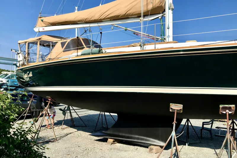 Slide: The Image of 2002 Sabre 402 sailboat on stands, green hull, tan covers, outdoor setting. - 4