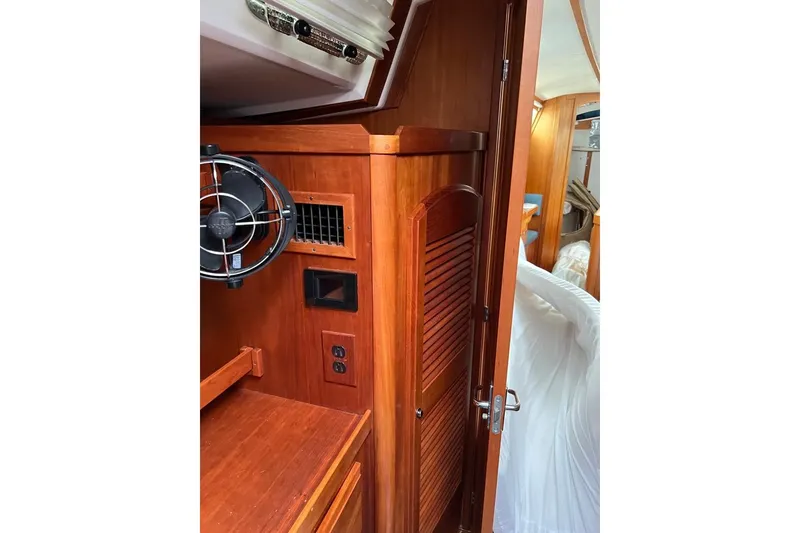 Slide: The Image of Cozy cabin interior of 2002 Sabre 402 sailboat with wooden cabinetry and blue cushions. - 42