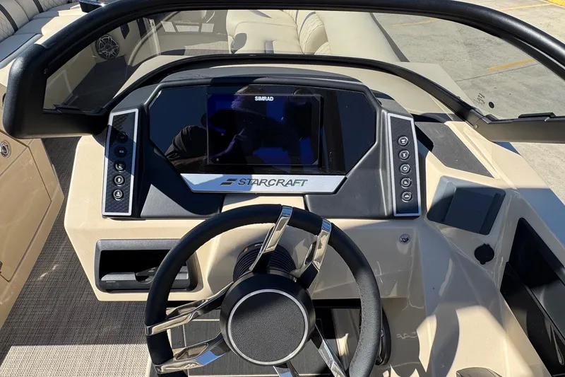 Slide: The Image of 2026 Starcraft RX 25 Q DC boat dashboard with steering wheel and control panel. - 11