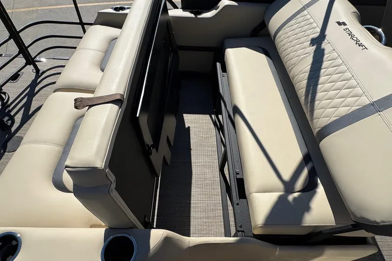 Slide: The Image of 2026 Starcraft RX 25 Q DC boat interior with beige seating and cup holders. - 16