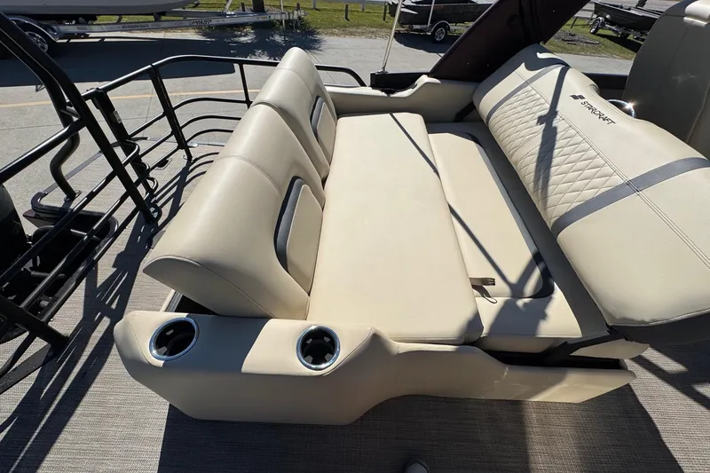 Slide: The Image of 2026 Starcraft RX 25 Q DC boat interior with beige seating and cup holders. - 18