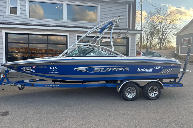 The Image of 2005 Supra Launch 22 SSV boat on trailer, parked outside a building. - 0