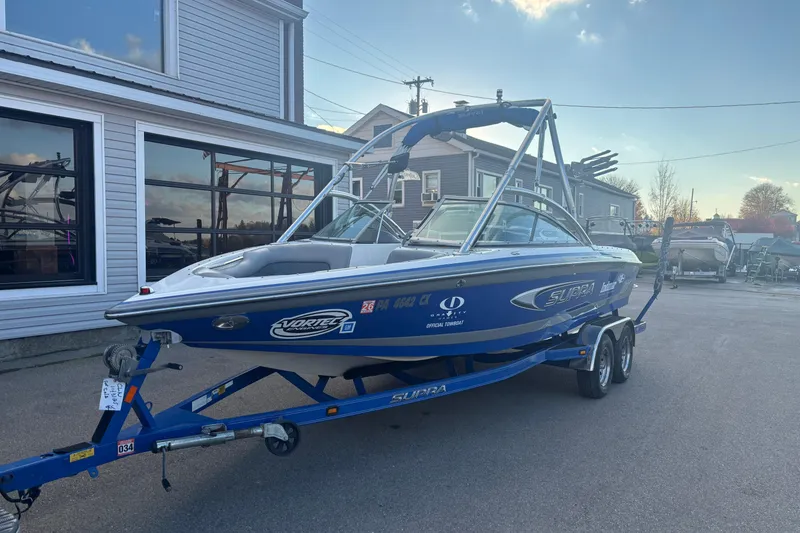 Slide: The Image of 2005 Supra Launch 22 SSV boat on trailer, parked outside a building. - 3