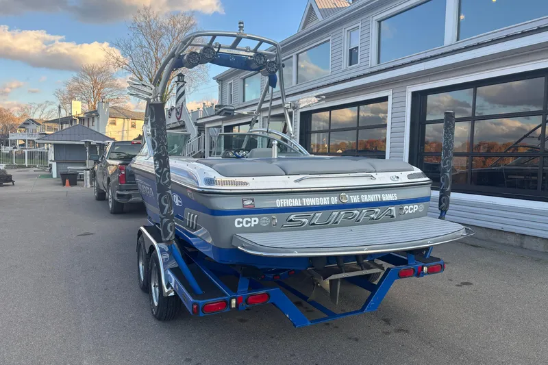 Slide: The Image of 2005 Supra Launch 22 SSV boat on trailer, parked near a building under a blue sky. - 4