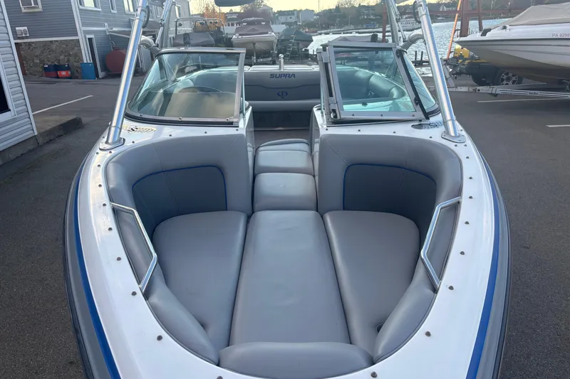 Slide: The Image of 2005 Supra Launch 22 SSV boat with spacious seating, docked at a marina. - 7