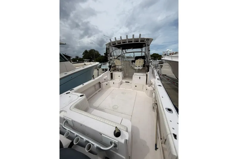 Slide: The Image of 2001 Grady-White Marlin 300 boat with spacious deck and seating, docked under cloudy skies. - 11