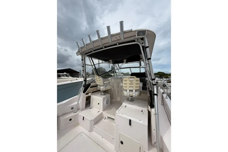 Slide: The Image of 2001 Grady-White Marlin 300 boat interior with helm and seating under cloudy sky. - 16