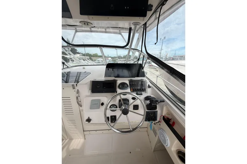 Slide: The Image of 2001 Grady-White Marlin 300 boat cockpit with steering wheel and navigation controls. - 21