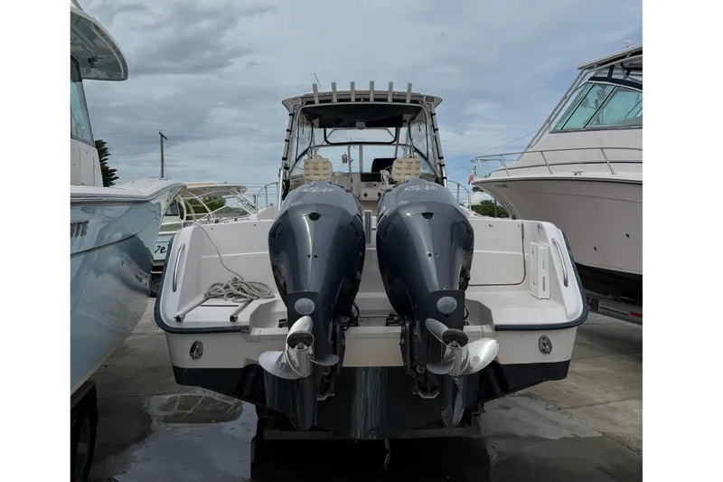 Slide: The Image of 2001 Grady-White Marlin 300 boat with dual outboard motors, docked under cloudy skies. - 28