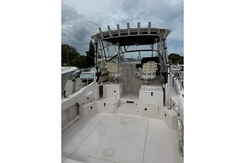 Slide: The Image of 2001 Grady-White Marlin 300 boat interior with seating and helm, under cloudy sky. - 7