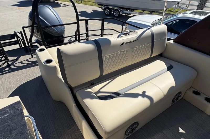 Slide: The Image of 2026 Starcraft RX 25 Q DC boat interior with beige seating and cup holders. - 12