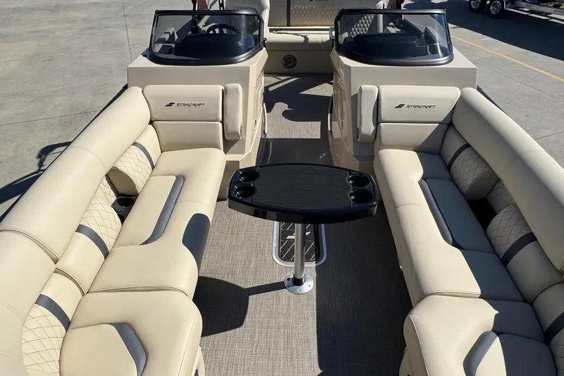 Slide: The Image of 2026 Starcraft RX 25 Q DC boat interior with beige seating and central table. - 5
