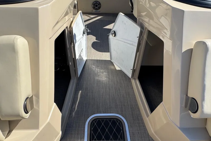 Slide: The Image of Interior view of 2026 Starcraft RX 25 Q DC boat with open storage compartments. - 7