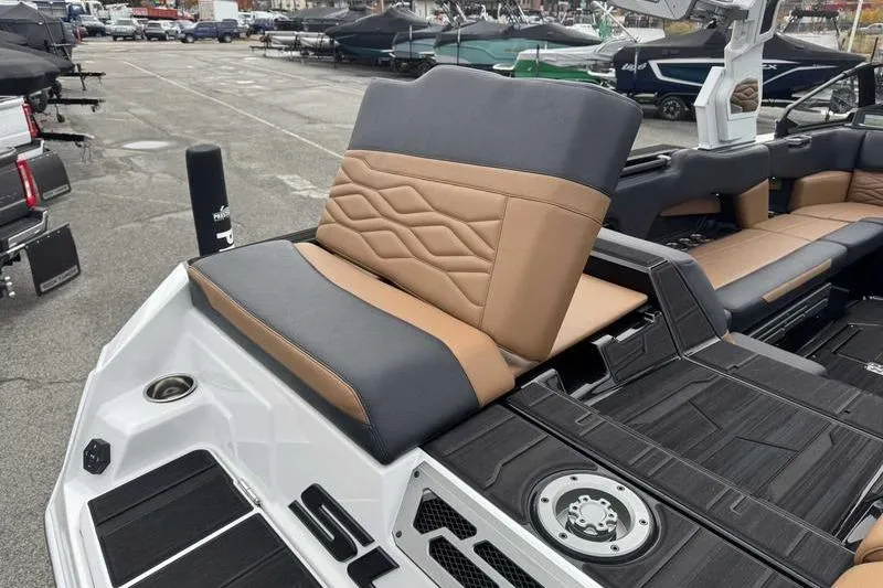 Slide: The Image of 2026 Supra SE boat interior with tan and black seating, cup holders, and speakers. - 13