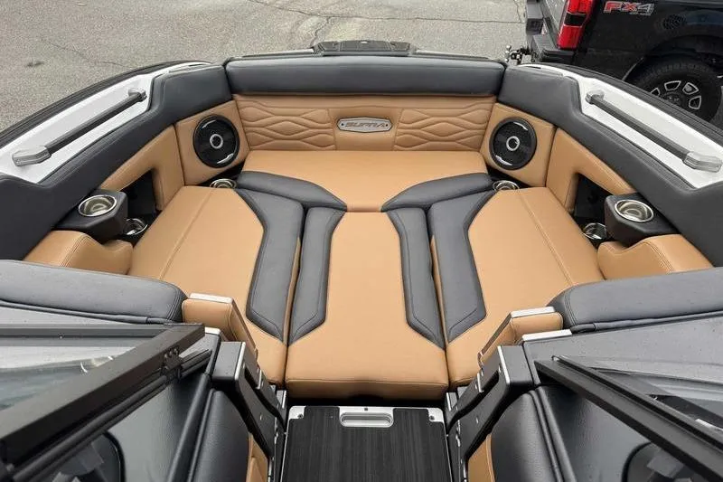 Slide: The Image of 2026 Supra SE boat interior with tan and gray seating at a marina. - 14