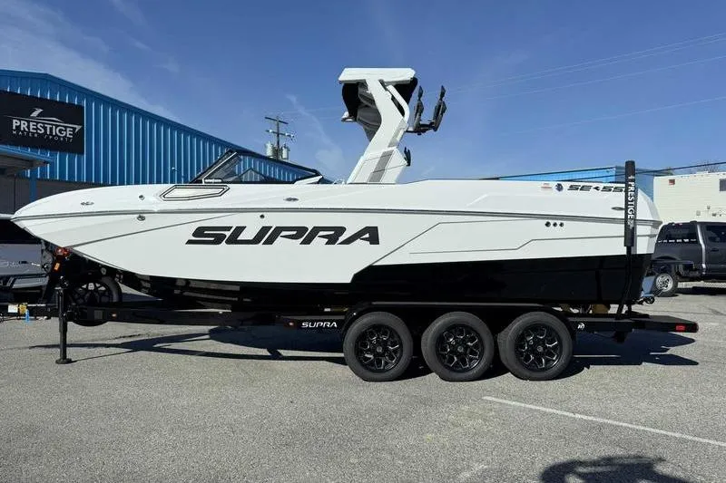 Slide: The Image of 2026 Supra SE boat on trailer, sleek design, parked outdoors. - 4