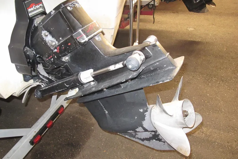 Slide: The Image of 1995 Harris FloteBote Legend 240 boat motor with propeller, featuring a MerCruiser outdrive. - 13