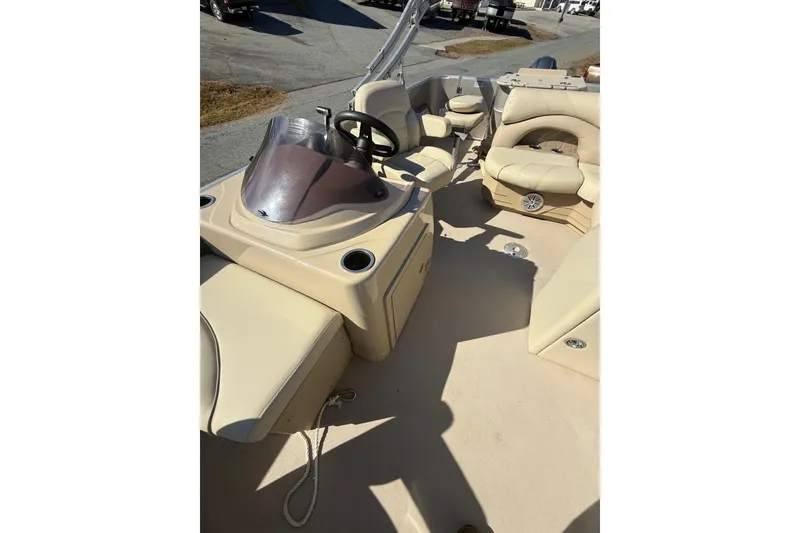 Slide: The Image of 2018 Sylvan Mirage Fish 8520 4-PT boat interior with beige seating and steering console. - 18