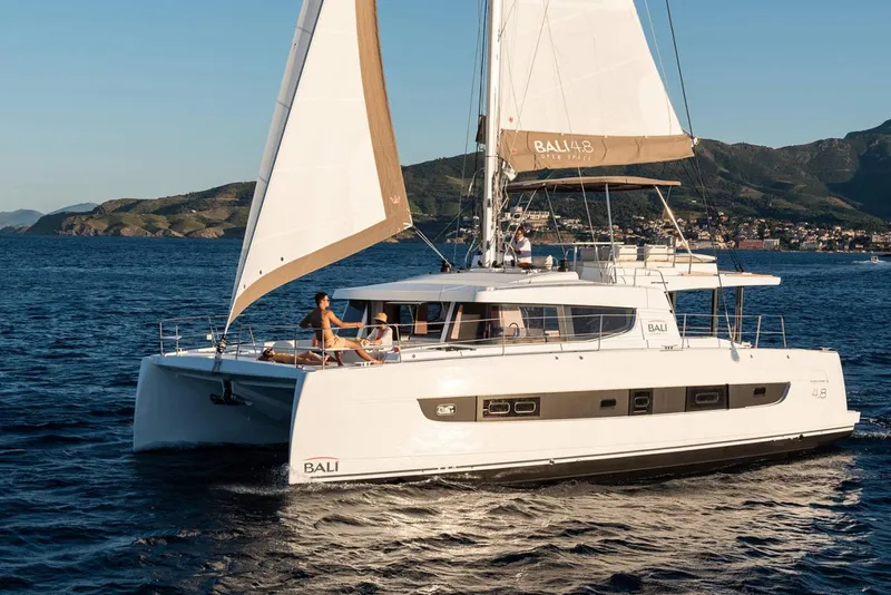 The Image of 2021 Bali 4.8 catamaran sailing on open sea with scenic mountain backdrop. - 0