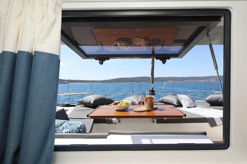 Slide: The Image of Bali 4.8 yacht interior view with ocean backdrop, featuring a dining setup, 2021 model. - 24