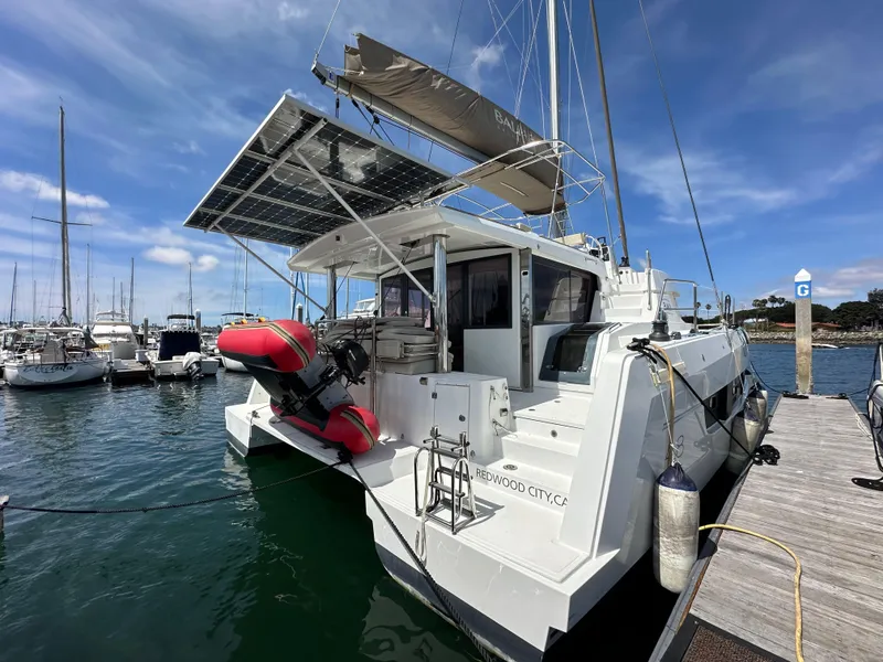 Slide: The Image of 2021 Bali 4.8 catamaran docked at marina with solar panels and dinghy. - 7