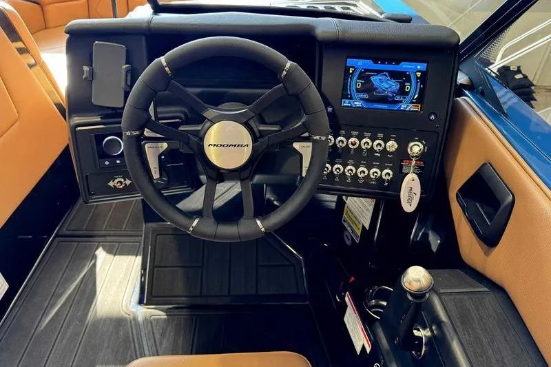 Slide: The Image of 2026 Moomba Tykon boat dashboard with steering wheel and digital display. - 12