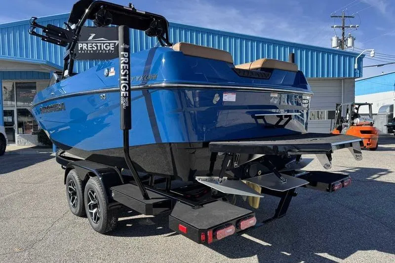 Slide: The Image of 2026 Moomba Tykon boat in blue, parked on a trailer outside a building. - 4