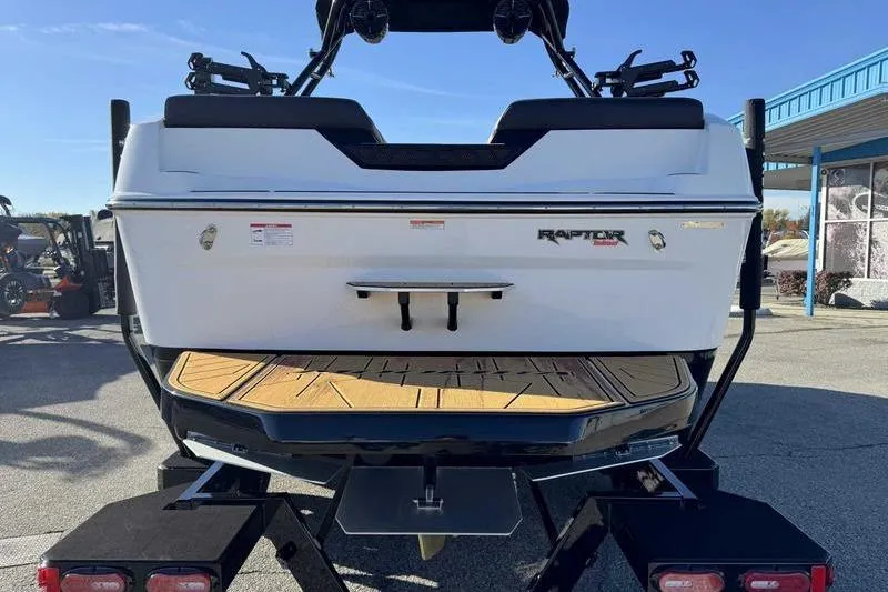 Slide: The Image of 2026 Moomba Tykon boat rear view with Raptor engine branding, parked on a trailer. - 8