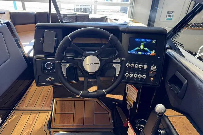 Slide: The Image of 2026 Moomba Tykon boat dashboard with steering wheel and digital display. - 9