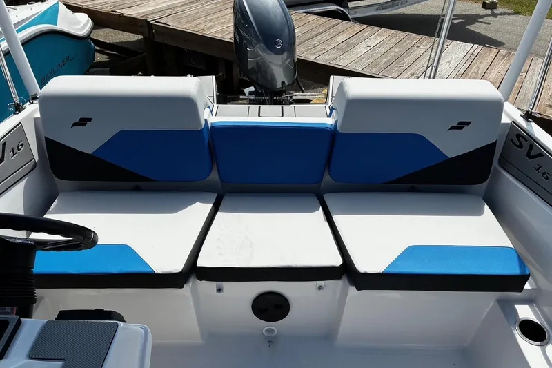 Slide: The Image of 2026 Starcraft SV 16 OB boat interior with blue and white seating, docked at a wooden pier. - 14