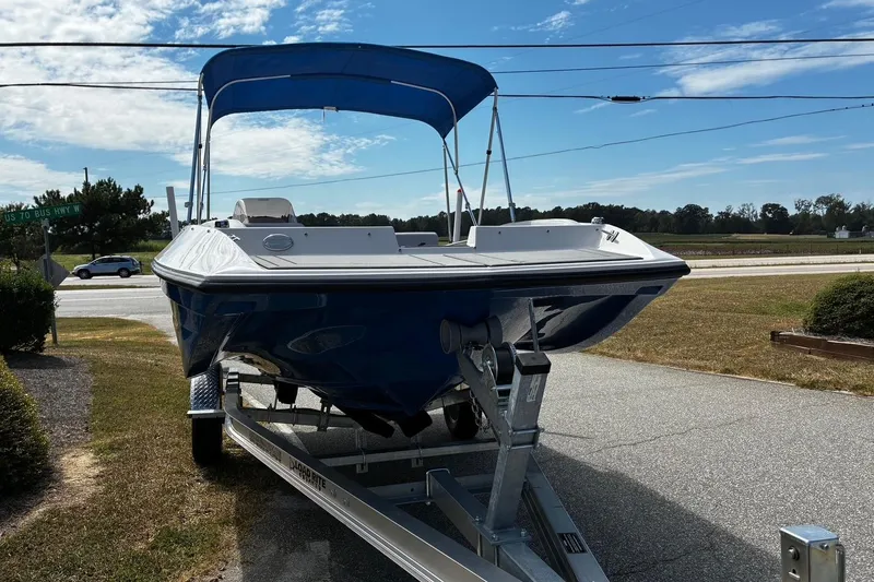 Slide: The Image of 2026 Starcraft SV 16 OB boat on trailer, blue hull, parked near highway under clear sky. - 5