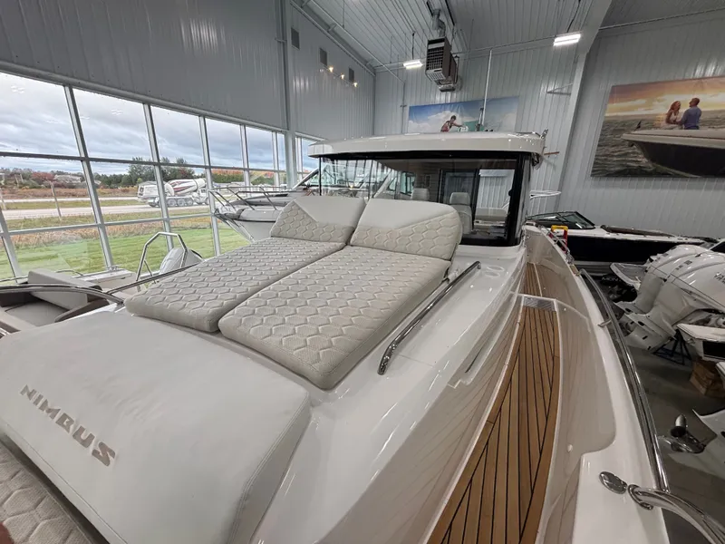 Slide: The Image of 2026 Nimbus Commuter 11 MKII Legacy Edition boat with cushioned deck in showroom. - 10