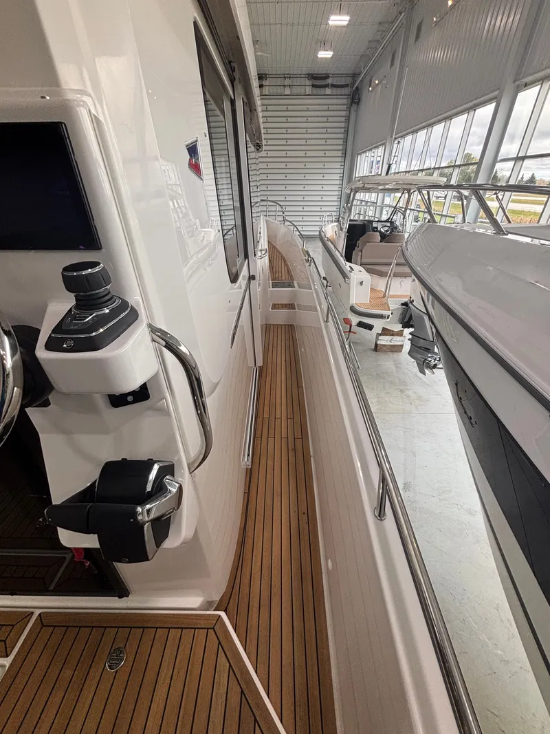 Slide: The Image of Nimbus Commuter 11 MKII Legacy Edition 2026 in a showroom, showcasing sleek design and wooden deck. - 4