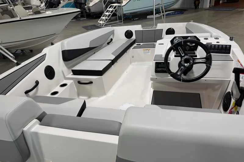 Slide: The Image of 2026 Starcraft SV 16 OB boat interior with modern seating and steering wheel in showroom. - 7
