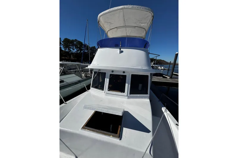 Slide: The Image of 1982 Marine Trader Europa boat docked, displaying American flag, clear blue sky background. - 10