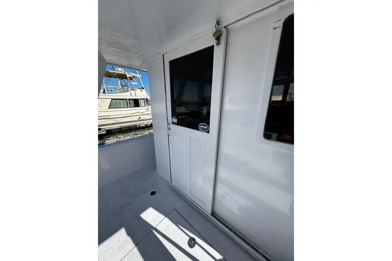 Slide: The Image of 1982 Marine Trader Europa boat with flybridge, docked under clear blue sky. - 13