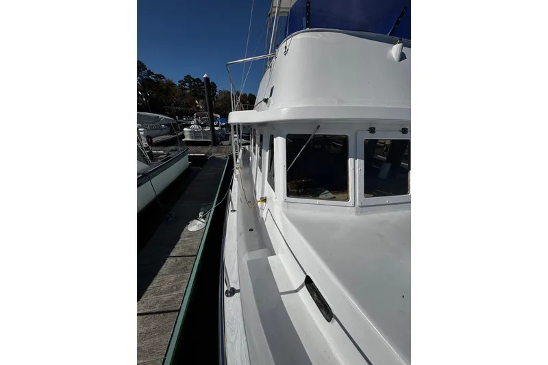 Slide: The Image of 1982 Marine Trader Europa docked at marina under clear blue sky. - 33