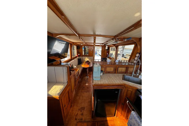 Slide: The Image of 1982 Marine Trader Europa boat with yellow power cable on deck. Starboard view of the sliding door entry leading to the interior helm station - 37
