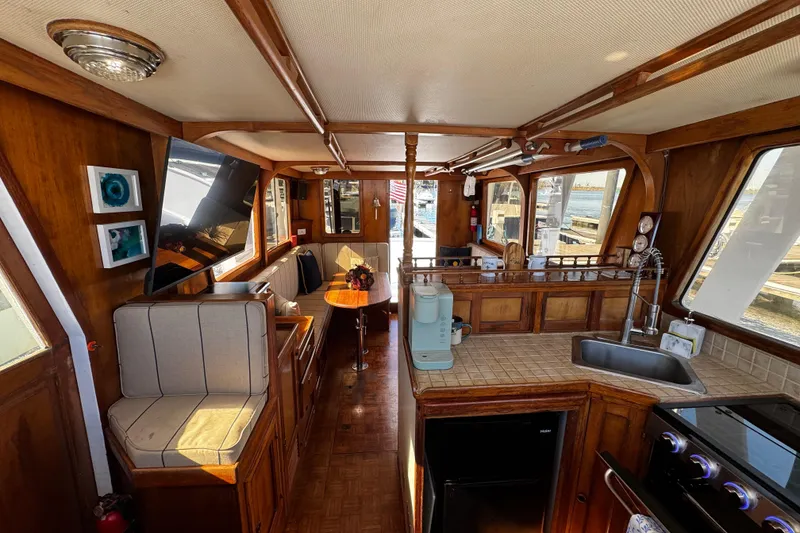 Slide: The Image of 1982 Marine Trader Europa interior with wooden flooring and built-in Haier refrigerator. - 64