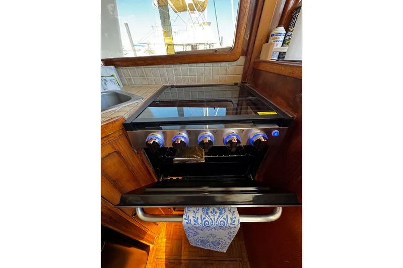 Slide: The Image of 1982 Marine Trader Europa kitchen with modern stove and wooden cabinetry. - 67