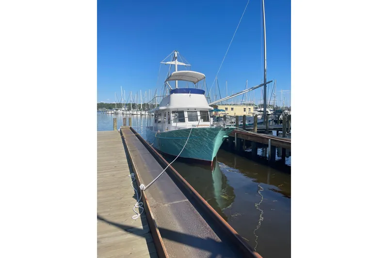 Slide: The Image of 1982 Marine Trader Europa boat named Sandpiper docked, featuring an American flag and bird graphic. - 7