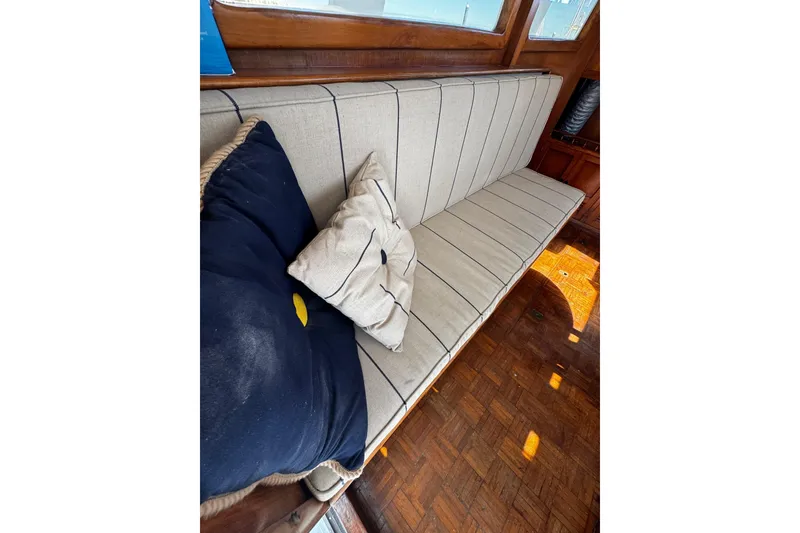 Slide: The Image of 1982 Marine Trader Europa interior with cushioned seating and decorative pillows. - 78